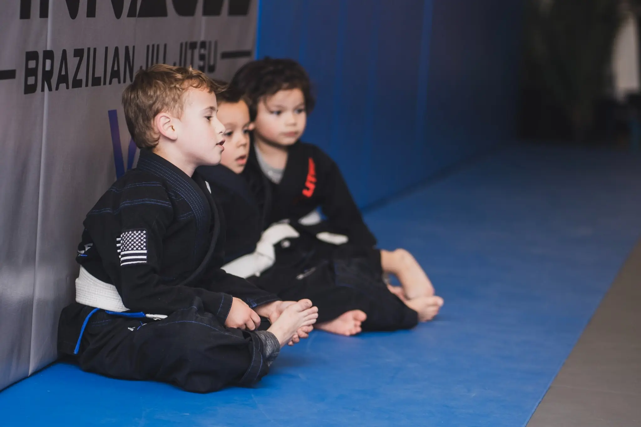 Kids lined up on the mats during a youth Brazilian Jiu Jitsu class